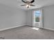 Standard-size bedroom featuring carpet, neutral paint, fan, and a window with outside views at 176 Butler Rd, Brooks, GA 30205