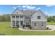Charming two-story home with a welcoming front porch, stone accents, and manicured landscaping at 176 Butler Rd, Brooks, GA 30205
