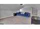 Upstairs living room with a large blue couch, carpeted floor and side table at 176 Butler Rd, Brooks, GA 30205