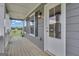 Covered porch with gray siding, white columns, and a door and sidelight at 176 Butler Rd, Brooks, GA 30205