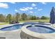 In-ground swimming pool with hot tub and comfortable outdoor seating area at 176 Butler Rd, Brooks, GA 30205
