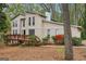 Inviting two-story home features a spacious wooden deck, enhancing outdoor living, surrounded by lovely trees and greenery at 5296 Golfcrest Cir, Stone Mountain, GA 30088