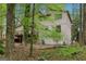 Tan home exterior featuring a wooden deck surrounded by vibrant green foliage and trees at 5296 Golfcrest Cir, Stone Mountain, GA 30088