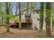 Exterior view of a tan home featuring a deck, surrounded by mature trees and natural landscape at 5296 Golfcrest Cir, Stone Mountain, GA 30088