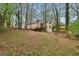 Exterior of a tan home, complete with a wooden deck and surrounded by lush trees and natural beauty at 5296 Golfcrest Cir, Stone Mountain, GA 30088