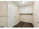 Laundry room with dark floors, white cabinets, and an access door at 5296 Golfcrest Cir, Stone Mountain, GA 30088