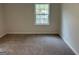 Cozy bedroom with a window, neutral walls, and plush carpeting at 1751 S Olympian Way, Atlanta, GA 30310