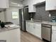 Modern kitchen featuring stainless steel appliances, white cabinets, and granite countertops at 1751 S Olympian Way, Atlanta, GA 30310