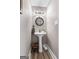 A powder room with a pedestal sink, round mirror, updated lighting, and vinyl flooring at 105 Honey Creek Rd, Mcdonough, GA 30252