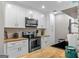 White cabinets, wood countertops, stainless steel appliances, and herringbone backsplash in the kitchen at 105 Honey Creek Rd, Mcdonough, GA 30252