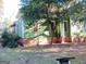 Side of a two-story home with green siding and mature trees, with several cats nearby at 109 Smith St, Locust Grove, GA 30248