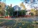 Two story home featuring a covered front porch, unique green siding, and a brick foundation at 109 Smith St, Locust Grove, GA 30248