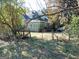 View of the two-story home with green siding partially obscured by mature trees and an old gate at 109 Smith St, Locust Grove, GA 30248