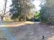 Exterior shot of a home from a distance, showing a long driveway and large trees at 109 Smith St, Locust Grove, GA 30248