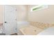 Bright bathroom features a soaking tub, tile surround, and a neutral color palette at 155 Duncans Mill Dr, Locust Grove, GA 30248