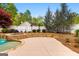 A stone pool with hot tub is bordered by a stone retaining wall with lawn beyond at 155 Duncans Mill Dr, Locust Grove, GA 30248