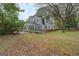 View of the house from the yard showing a screened-in porch and mature trees at 6140 Ginn Se St, Covington, GA 30014