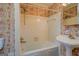 Bathroom featuring a tub with white tiling and patterned wallpaper at 6140 Ginn Se St, Covington, GA 30014