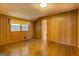 Spacious bedroom with wood paneling and gleaming hardwood floors offers natural light and a connected bathroom at 6140 Ginn Se St, Covington, GA 30014