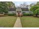 Charming home with a red front door, manicured lawn, and lush landscaping at 6140 Ginn Se St, Covington, GA 30014
