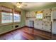 Eat-in kitchen featuring wood floors, white cabinets, and natural light from multiple windows at 6140 Ginn Se St, Covington, GA 30014