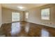 Large living room with hardwood floors and three windows providing ample natural light at 6140 Ginn Se St, Covington, GA 30014
