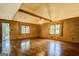 Spacious living room featuring hardwood floors, wood paneled walls, and large windows with natural light at 6140 Ginn Se St, Covington, GA 30014