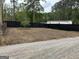 A view of the backyard with a black fence and gravel road at 6121 N Main Se St, Acworth, GA 30101