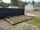 Small garden containing young vegetable plants, surrounded by a low wood perimeter at 6121 N Main Se St, Acworth, GA 30101