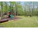 Large backyard with a playground and wooded area for outdoor fun at 70 Barrington Farms Ct, Sharpsburg, GA 30277