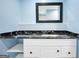 Bathroom vanity features a black countertop, white cabinetry, and a decorative framed mirror at 70 Barrington Farms Ct, Sharpsburg, GA 30277