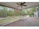 Relaxing covered deck features a ceiling fan and views of the lush backyard and wooded area at 70 Barrington Farms Ct, Sharpsburg, GA 30277