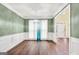 Bright dining area featuring hardwood floors, a modern chandelier, and wainscoting with view of front entryway at 70 Barrington Farms Ct, Sharpsburg, GA 30277