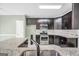 Modern kitchen features dark cabinets, stainless steel appliances, and granite countertops at 70 Barrington Farms Ct, Sharpsburg, GA 30277