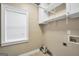Functional laundry room with built-in shelving and a window for natural light at 70 Barrington Farms Ct, Sharpsburg, GA 30277