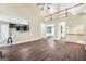 Open-concept living room with hardwood floors, view to the kitchen, and a staircase to upper level at 70 Barrington Farms Ct, Sharpsburg, GA 30277