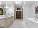 Elegant bathroom featuring double vanity, soaking tub, and decorative wall panels at 140 Newhaven Dr, Fayetteville, GA 30215