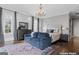 Staged bedroom with a large bed, chandelier, sofa, and beautiful rug at 140 Newhaven Dr, Fayetteville, GA 30215