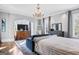 Spacious staged bedroom featuring large windows, a dresser, television, and a bed with striped blanket at 140 Newhaven Dr, Fayetteville, GA 30215
