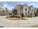 Stately home showcasing meticulous landscaping, a circular driveway, and sophisticated architectural details at 140 Newhaven Dr, Fayetteville, GA 30215