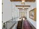 Hallway with wood beams, large windows, red rug, and art piece at 140 Newhaven Dr, Fayetteville, GA 30215