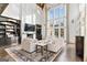 Sun-drenched living room features high ceilings, large windows, a fireplace, custom built-ins, and plush seating at 140 Newhaven Dr, Fayetteville, GA 30215