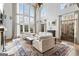 Sun-drenched living room features high ceilings, large windows, a fireplace, custom built-ins, and plush seating at 140 Newhaven Dr, Fayetteville, GA 30215