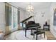 Elegant living room featuring a grand piano, large windows, and custom wall paneling at 140 Newhaven Dr, Fayetteville, GA 30215