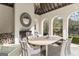 Covered outdoor dining area featuring a stone fireplace, arched openings, and views of the backyard at 140 Newhaven Dr, Fayetteville, GA 30215