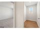 Hallway view of two bedrooms, one carpeted and one with hardwood floors, showing versatile living spaces at 315 Arwen Dr # 105, Mcdonough, GA 30252