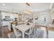 Charming dining area with a farmhouse-style table, elegant lighting, and an open view to the kitchen and living spaces at 108 White Oak Tl, Cumming, GA 30028