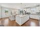 Spacious kitchen featuring a large island, white cabinetry, stainless steel appliances, and an adjacent dining area at 108 White Oak Tl, Cumming, GA 30028