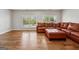 Living room featuring hardwood floors, natural light from shuttered windows, and leather furniture at 108 White Oak Tl, Cumming, GA 30028
