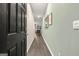 A hallway with hardwood floors leads to a decorated living space, enhancing the home's welcoming interior at 325 Silver Moon Dr, Loganville, GA 30052